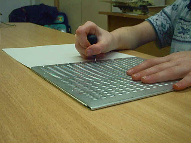 template for punching out Braille letters