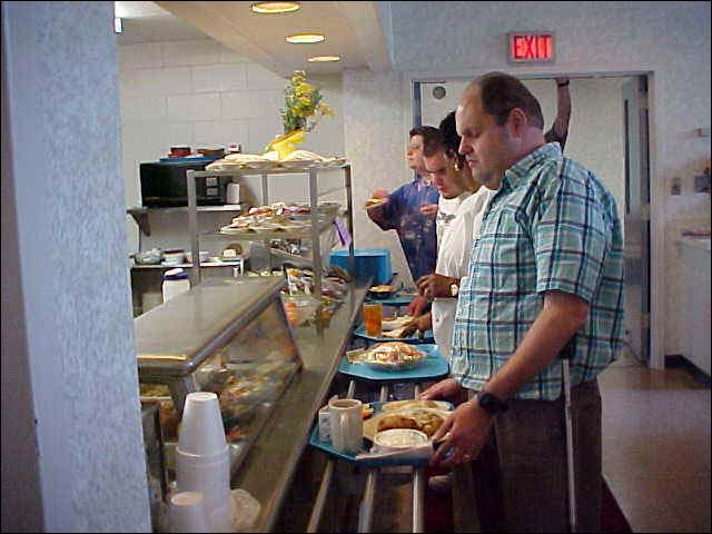 B lind person standing in a cafeteria food line