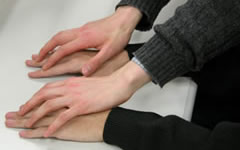 A close-up of hand-on-hand finger brailling